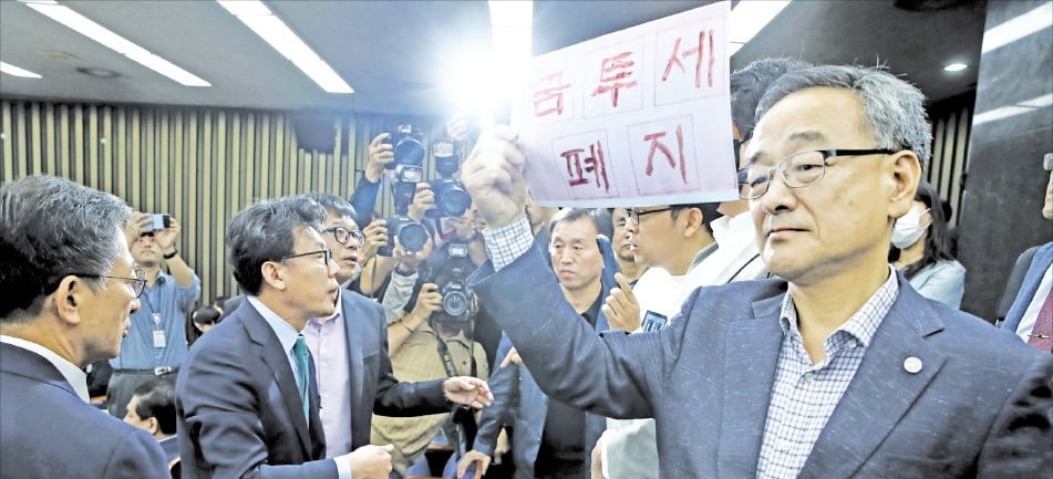 지난 달 24일 민주당의 금융투자소득세 토론회에 개인투자자들도 참석을 요구하며 민주당 의원들과 실랑이를 벌이고 있다. 뉴스1